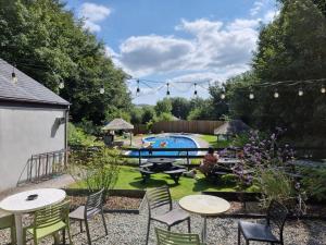 a backyard with a table and chairs and a pool at Two Bedroom Barn Conversion in Newquay