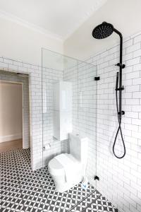 een witte badkamer met een toilet en een douche bij Chic Bondi Beach Pad in Sydney