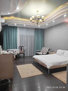 a bedroom with a bed and a couch and a chair at Altyn in Astana