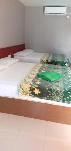 Dos camas individuales en una habitación con en Inapan Aishah, en Pantai Cenang