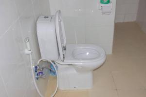 a white toilet sitting on top of a tiled floor at Summer Dream Lodge in Paje