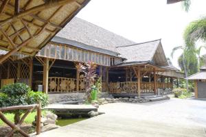 un gran edificio de madera con porche en Kuraya Hotel Residence en Bandar Lampung