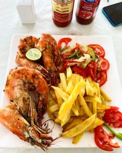 un plato de comida con camarones y papas fritas en Summer Dream Lodge, en Paje