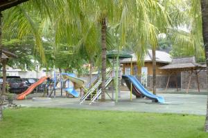 een speeltuin met glijbanen en een palmboom bij Kuraya Hotel Residence in Bandar Lampung