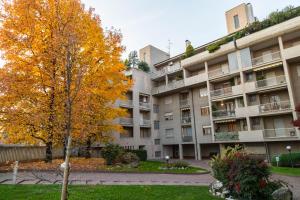 um prédio de apartamentos com uma árvore amarela em frente em SAREMY - Home Sweet Home em Paderno Dugnano
