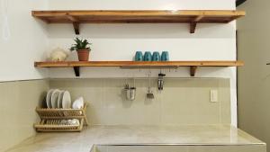 a kitchen with a shelf on the wall at Yayay Homestay in General Luna