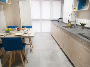 a kitchen with a table and blue chairs at San Antón Piso de lujo centro con Aire ac by Apartamentos Logrono in Logroño
