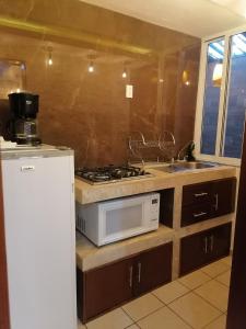 a kitchen with a stove and a sink and a microwave at Posada Castillo in Zacatlán +37 photos