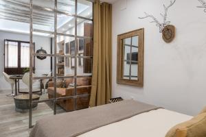 un dormitorio con una cama y un espejo en Loft Gracia- CTH Granada, en Granada