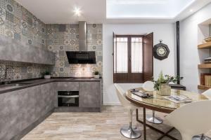 una cocina con mesa y sillas y un reloj en la pared en Loft Gracia- CTH Granada, en Granada