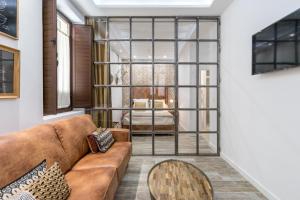 una sala de estar con un sofá y una mesa en Loft Gracia- CTH Granada, en Granada