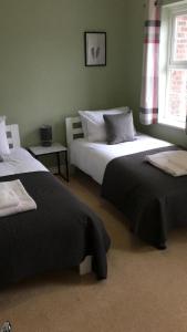 um quarto com 2 camas e uma janela em Bullfinch House em Harleston