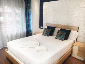 a bedroom with a large white bed with a white bird on it at San Antón Piso de lujo centro con Aire ac by Apartamentos Logrono in Logroño