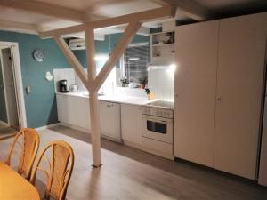 uma cozinha com electrodomésticos brancos e uma mesa e cadeiras em Gæstebolig,Tørresøvej 87 em Otterup