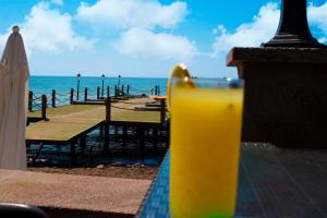 Sazlı的住宿－Kayalar Blue Beach Hotel，坐在海边的桌子上喝一杯