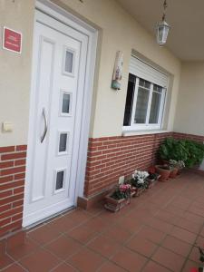 a white door on the side of a house with plants at Casa Rotella in Puente San Miguel