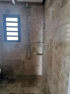 a bathroom with a shower with a window at Ti Kaz en l'R in Saint-Leu