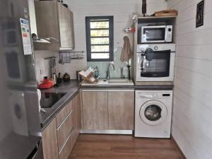 eine Küche mit einer Waschmaschine und einer Mikrowelle in der Unterkunft Ti Kaz en l'R in Saint-Leu