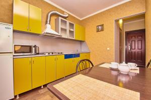 トムスクにあるКвартиры на Карла Ильмераのキッチン(黄色のキャビネット、木製テーブル付)