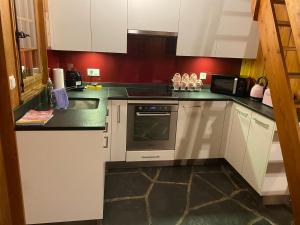 a kitchen with white cabinets and a stove top oven at chalet à diolly in Savièse