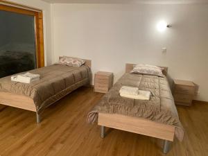 two beds in a room with wooden floors at chalet à diolly in Savièse