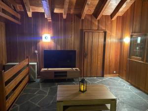 ein Wohnzimmer mit einem TV und einem Tisch in der Unterkunft chalet à diolly in Savièse