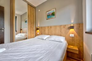a bedroom with a large white bed and a mirror at Zlatna zona 59 (Titova vila) in Zlatibor +26 photos
