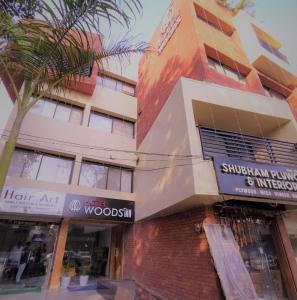 a building with a palm tree in front of it at Hotel Wood Inn in Hoshangābād