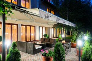 a building with a patio with furniture and plants at Aventinus Hotel in Nyíregyháza