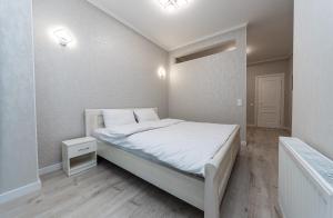 a bedroom with a large white bed with white sheets at FlatRent Drahomanova 2a in Kyiv