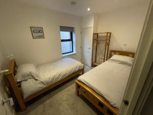 Un dormitorio con dos camas y una ventana. en 10 Argyle Court, en Whitby