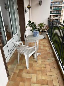 een patio met een tafel en stoelen op een balkon bij LE CHOUKI in Annecy