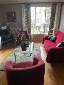 a living room with two red couches and a tv at LE CHOUKI in Annecy