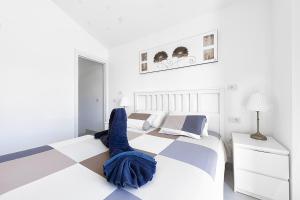 a white bedroom with a bed and a checkerboard floor at Villetta Green oasis club in Maspalomas