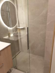 y baño con ducha y puerta de cristal. en Ostseeresidenz Niechorze, en Niechorze