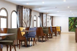 Un comedor con mesas y sillas y ventanas. en Hôtel l'Europe, en Yibuti 9 fotos más