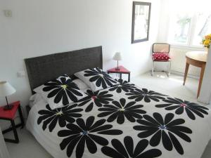 a bedroom with a bed with a black and white blanket at Estivado Sea View - Mer à 50 m et Piscine avec Spa in Cassis