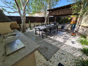 een patio met een tafel en stoelen in de achtertuin bij נופש אזאר-וילה in ‘Isfiyā