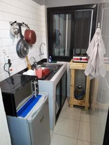 cocina con fregadero y microondas en Résidence Safie, en Yof