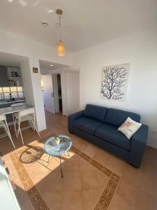 a living room with a blue couch and a table at Costa Calma Sun & Beach Apartment - wifi & pool in Costa Calma