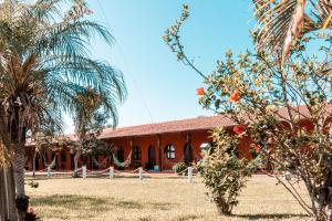 ein Gebäude mit einer Palme davor in der Unterkunft Pousada Elementais do Rosa in Praia do Rosa