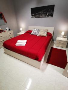 una camera da letto con un grande letto rosso con una coperta rossa di B&b Ci Vediamo Da Mario a Caserta