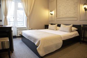 Un dormitorio con una cama grande y una ventana en Mini Hotel Jazzclub, en San Petersburgo