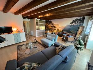 a living room with a blue couch and a wall mural at Colombages de la Lauch in Colmar