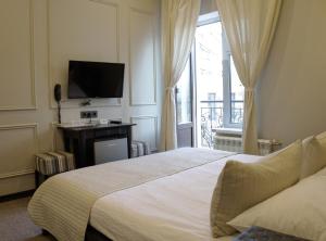 1 dormitorio con 1 cama, TV y ventana en Mini Hotel Jazzclub, en San Petersburgo
