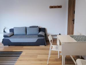 a living room with a blue couch and a table at Apartamenty Kościuszki in Stronie Śląskie