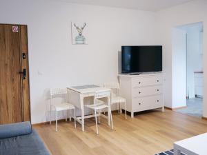 a living room with a table with chairs and a tv at Apartamenty Kościuszki in Stronie Śląskie