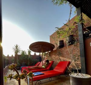 a woman laying on a red couch on a patio at Riad La Porte Rouge in Marrakesh