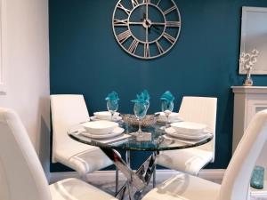 une salle à manger avec une table et une horloge murale dans l'établissement Luxury Modern 2 Bed Apartment, FREE UNDERCROFT PARKING FOR 1 CAR, à Southampton