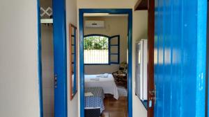 a hallway with a room with a bed and a window at Pousada Canoeiro in Ubatuba